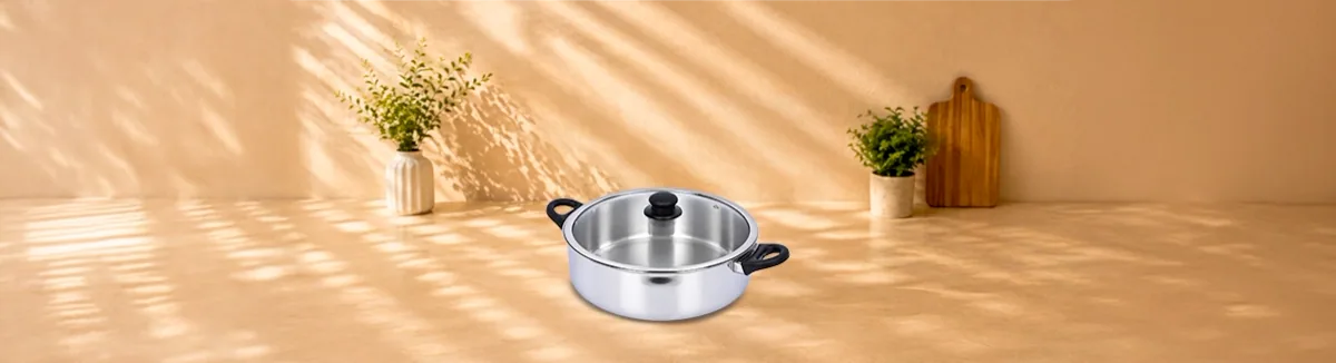 Wide steel pan with black side handles and a glass lid