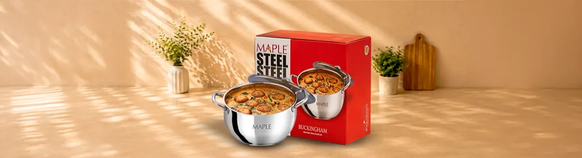 Steel handi with two side handles holding curry, red printed box behind