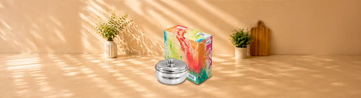 Steel serving bowl with a domed lid and knob, beside a colourful carton