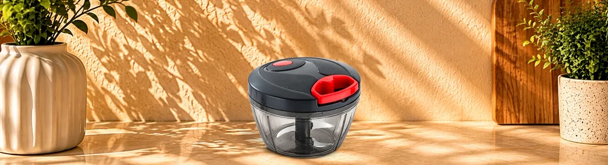 Clear bowl chopper with a dark lid and a red pull handle on top